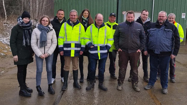EUROQUARZ-Mitarbeiter und Geschäftspartner bei der Werksbesichtigung vor einer Halle
